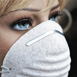 防塵マスクをする女性の画像